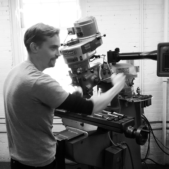 Adam explains the functioning of one of their Bridgeport vertical mills.