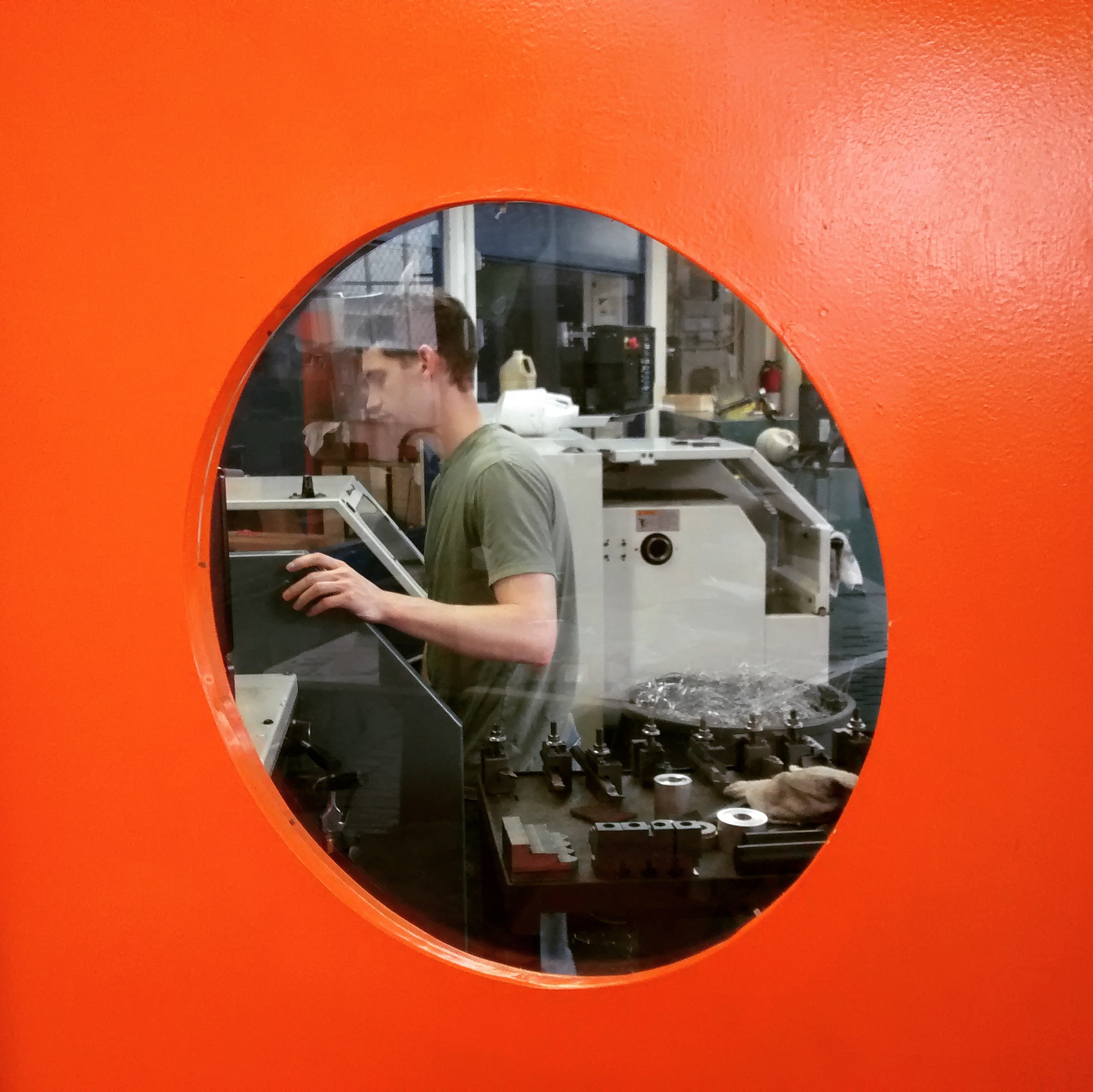 Joel Dau reams out a Sinar Norma lens board on a PROTO TRAK TRL 1440P Lathe in the machine shop at S.K. Grimes